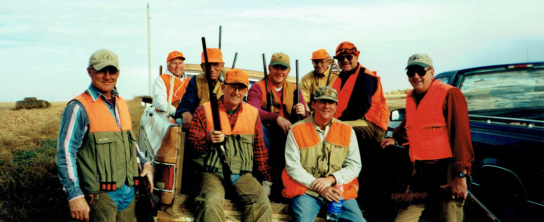 Hunting dogs retrieving pheasants in cattails